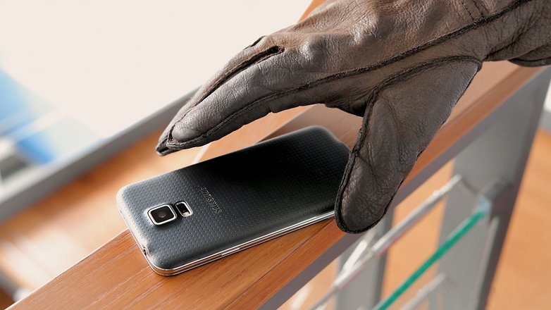 Hand mit Handschuh greift nach altem Samsung-Handy