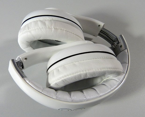 Weiße Over-Ear-Kopfhörer mit elegantem Design, zum Verstauen gefaltet.